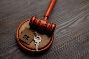 New Jersey Division Of Property And Preservation Of Assets - Judge gavel and key chain in shape of two splitted part of house on wooden background. Concept of real estate auction or dividing house when divorce, division of property, real estate, law system