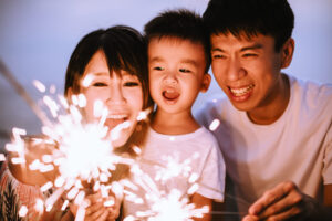 Parent Coordinator - happy family celebrating new year with sparklers